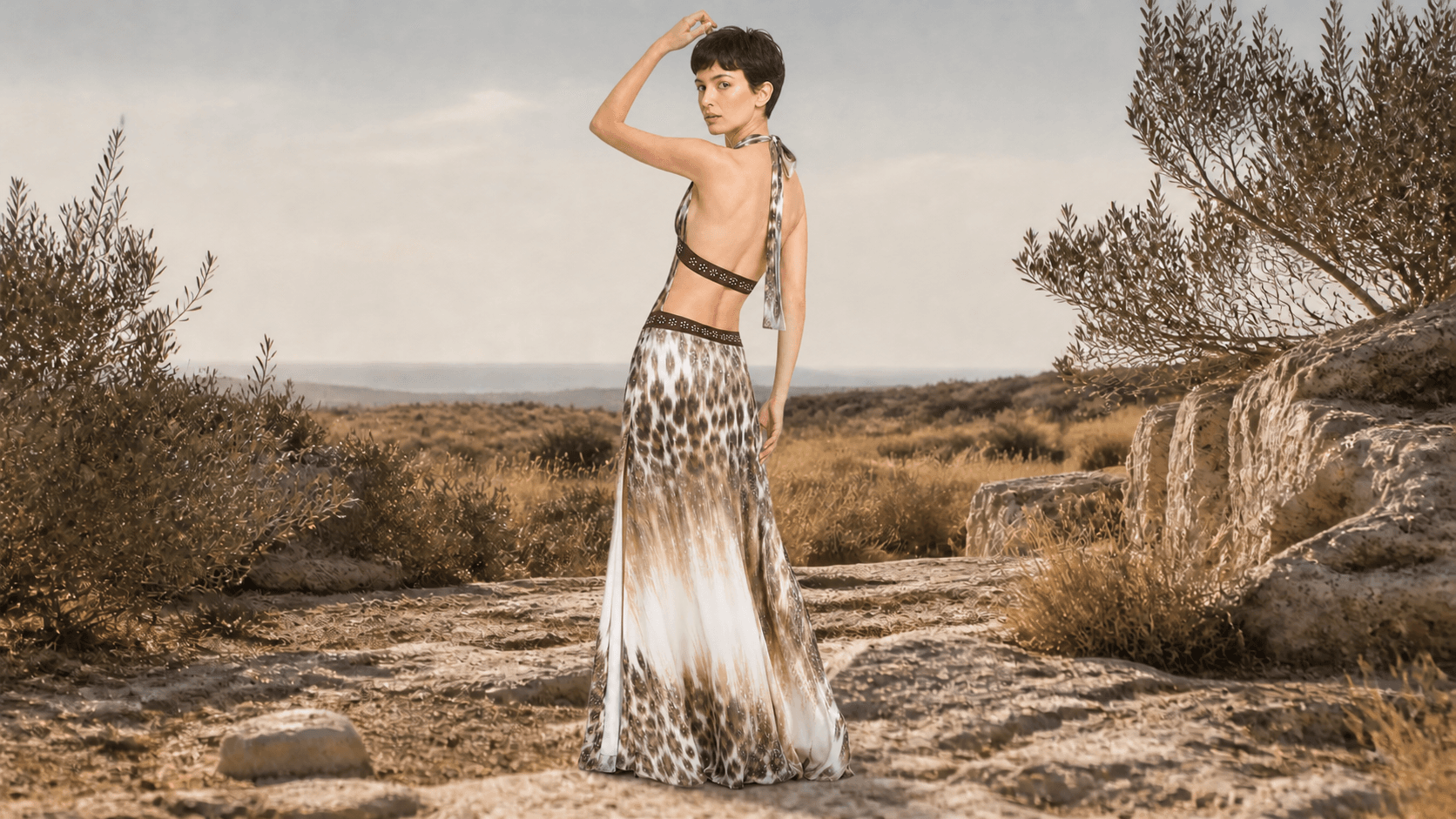 Model wearing the Zélie leopard maxi dress in a Mediterranean landscape
